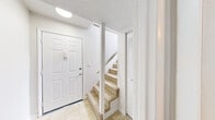 Located at 5840 Lake Resort Terrace in Chattanooga, Tennessee, this two-floor residence offers a functional and well-organized layout with a clean, neutral aesthetic throughout. The entry level welcomes you with tile flooring, a carpeted staircase, and a louvered storage closet, setting a practical tone from the moment you arrive. The main living area is expansive, featuring plush wall-to-wall carpeting and a fireplace that serves as a central focal point, adding character to the space. The kitchen is equipped with white cabinetry, granite-style countertops, a double stainless steel sink, and an electric range, all complemented by wood-style flooring for easy maintenance. A half bath on this level features wood-style flooring and a granite-style vanity countertop. Upstairs, the bedrooms are generously sized with soft carpeting, natural light from windows with outdoor views, and ample closet space featuring louvered bifold doors with built-in shelving and hanging rods. One bedroom provides direct access to a private bathroom with a wide vanity and large mirror. The full bathroom includes tile-surround tub and shower combination with beige tile, a toilet, and a granite-style countertop vanity, completing the home's practical amenities.