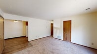 Located at 4826 Jersey Ridge Rd in Davenport, Iowa, this single-floor unit offers three bedrooms, one bathroom, and a practical layout designed for comfortable everyday living. The living area features plush carpeting and a sliding glass door that opens to a private balcony, allowing natural light to fill the space and offering outdoor views of the surrounding grounds. A textured ceiling and warm wood-tone trim are consistent throughout, lending a cohesive and classic look. The kitchen is efficiently designed in a U-shaped configuration, featuring warm wood cabinetry, recessed lighting, light wood-style flooring, and white appliances including a refrigerator and range. Ample upper and lower cabinet storage makes the kitchen both functional and organized. The three bedrooms are carpeted and feature natural light through windows with blinds, warm wood-toned doors, and individual closets, with the primary bedroom being notably spacious. A hallway connects the bedrooms to the shared full bathroom, which includes a tub and shower combination. Throughout the unit, neutral wall tones and consistent wood trim detailing create a clean, understated aesthetic that offers a versatile canvas for personalization.