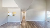 Located at 700 Stonehouse Dr in Napa, CA, this single-story, 3-bedroom, 2-bathroom home offers a well-designed layout with a variety of thoughtful features throughout. The living area immediately impresses with its dramatic vaulted ceilings and a vaulted-ceiling primary room, both finished with hardwood-style flooring that adds warmth and continuity to the space. Large windows throughout the home invite abundant natural light, creating a bright and airy atmosphere.

The kitchen is efficiently laid out with warm wood-toned cabinetry, a white electric range, and a window overlooking the backyard. A stacked washer and dryer unit is conveniently housed within the kitchen area. The primary bedroom is generously sized and features soaring ceilings, multiple windows with outdoor views, and direct access to a private ensuite bathroom equipped with a wide vanity, ample cabinetry, a large mirror, and a walk-in shower.

The two additional bedrooms are carpeted and well-proportioned, each with windows providing natural light and views to the outside. The second bathroom includes a bathtub and shower combination. A connecting hallway ties all rooms together seamlessly, making for a functional and comfortable floor plan throughout this Napa home.