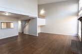 This two-story home in Midland, Texas offers a well-organized layout across both levels, combining functional design with comfortable living spaces. The main living area immediately stands out with its soaring vaulted ceilings and an abundance of natural light streaming through tall, stacked windows. A classic brick fireplace serves as the focal point of the room, complemented by warm hardwood flooring that extends throughout the main level.

The kitchen is well-equipped with rich oak cabinetry offering generous storage, a double sink, light countertops, and black appliances including a range and refrigerator. A pass-through window connects the kitchen to an adjacent area, enhancing the open flow between spaces. A hallway leads further into the home, providing access to additional rooms.

The bedrooms are carpeted and bright, each featuring ceiling fans and windows with blinds that allow natural light while maintaining privacy. The bathrooms are outfitted with extended vanities, warm wood cabinetry, large mirrors, and tiled shower-tub combinations, offering practical and functional layouts.

The second floor overlooks the main living area, adding to the home's sense of openness and vertical scale. Textured ceilings are consistent throughout, adding a traditional character to the overall design.