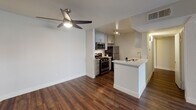 Located at 4605 Cahuenga Blvd in the North Hollywood neighborhood of Los Angeles, this single-floor residence showcases a clean, contemporary design throughout. Rich, dark hardwood flooring runs continuously across the living areas, creating a warm and cohesive aesthetic.

The open living area is bright and airy, with crisp white walls and a sliding glass door that opens to a private balcony, allowing natural light to fill the space. A ceiling fan with integrated lighting adds both comfort and function to the adjoining area.

The kitchen is well-appointed with gray shaker-style cabinetry, light quartz countertops, and a full suite of stainless steel appliances including a gas range, microwave, and refrigerator. A peninsula with a built-in sink provides additional prep space and serves as a natural divider between the kitchen and living area. Track lighting overhead ensures the workspace is well lit.

The bathroom continues the home's modern aesthetic, featuring a vessel sink set atop a white vanity with quartz countertops, a large mirror, and a shower-tub combination. Hardwood-style flooring extends into the bathroom, maintaining a consistent look throughout the unit.

Overall, the space presents a thoughtfully updated interior with neutral tones, modern finishes, and practical layouts suited for comfortable everyday living in a prime Los Angeles location.