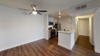 Located at 4605 Cahuenga Blvd in the North Hollywood neighborhood of Los Angeles, this single-floor residence showcases a clean, contemporary design throughout. Rich, dark hardwood flooring runs continuously across the living areas, creating a warm and cohesive aesthetic.

The open living area is bright and airy, with crisp white walls and a sliding glass door that opens to a private balcony, allowing natural light to fill the space. A ceiling fan with integrated lighting adds both comfort and function to the adjoining area.

The kitchen is well-appointed with gray shaker-style cabinetry, light quartz countertops, and a full suite of stainless steel appliances including a gas range, microwave, and refrigerator. A peninsula with a built-in sink provides additional prep space and serves as a natural divider between the kitchen and living area. Track lighting overhead ensures the workspace is well lit.

The bathroom continues the home's modern aesthetic, featuring a vessel sink set atop a white vanity with quartz countertops, a large mirror, and a shower-tub combination. Hardwood-style flooring extends into the bathroom, maintaining a consistent look throughout the unit.

Overall, the space presents a thoughtfully updated interior with neutral tones, modern finishes, and practical layouts suited for comfortable everyday living in a prime Los Angeles location.
