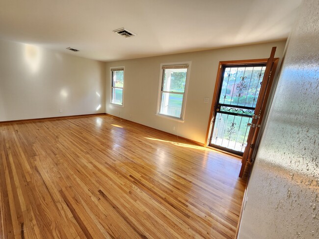 Large living room with good natural lighting. Enters into kitchen and dining room. - 139 Saratoga Dr