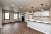 Located at 3174 Tripp St in Ames, Iowa, this single-floor, two-bedroom, one-bathroom home offers a practical and well-designed layout. The open-concept kitchen and living area serves as the heart of the home, featuring warm hardwood-style flooring, recessed lighting, and a clean, neutral color palette throughout. The kitchen is equipped with white shaker-style cabinetry with black hardware, white appliances including a range and microwave, a stainless steel sink, light countertops, and a peninsula with stylish pendant lighting — ideal for both cooking and casual dining.

The living area extends from the kitchen, offering an open and airy feel with additional recessed lighting and ample wall space. Both bedrooms are carpeted for comfort and feature ceiling fans, closets, and windows that bring in natural light with views of the surrounding neighborhood. The primary bedroom includes a sliding glass door to an outdoor balcony area, adding a pleasant outdoor connection. The full bathroom is outfitted with a tub/shower combo, a single vanity, and classic tile flooring. Two dedicated closets provide practical storage throughout the home.