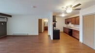 This single-floor residence at 3110 Nathan Ln N in Plymouth, Minnesota, offers a practical and well-organized layout designed for comfortable everyday living. The open-concept living area is finished with warm laminate wood flooring and features a sliding glass door with vertical blinds, allowing natural light to fill the space. A wall-mounted AC unit provides climate control, complemented by baseboard heating along the walls.

The galley-style kitchen is efficiently designed with rich dark wood cabinetry lining both sides, granite-look countertops, and black appliances including an electric range, refrigerator, and dishwasher. A built-in sink with ample counter space adds to the kitchen's functionality, and a textured ceiling completes the look.

The bedrooms feature plush carpeting, ceiling fans with light fixtures, wall-unit air conditioning, and windows dressed with vertical blinds. One bedroom includes a walk-in closet with built-in shelving for organized storage.

Two bathrooms serve the unit. The primary bathroom includes a wide vanity with dark wood cabinetry, a light-toned countertop, a large mirror with overhead lighting, and a tub-shower combination. The second bathroom is clean and straightforward, featuring a white tub-shower surround and laminate flooring. Throughout the unit, neutral tones and consistent flooring create a cohesive, move-in-ready atmosphere.