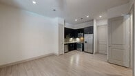 This contemporary apartment, located at 2310 Main St in Houston, offers 950 square feet of thoughtfully designed living space. The open-concept floor plan maximizes the use of space, creating a seamless flow between rooms. The kitchen is a highlight, featuring dark cabinetry contrasted with stainless steel appliances and a stylish subway tile backsplash. Light-toned wood-look flooring runs throughout, unifying the space and adding warmth.

The primary bedroom, measuring 190 square feet, provides ample space and includes a generous closet with built-in shelving. Both bathrooms showcase modern fixtures, granite countertops, and tiled shower areas. Large windows in the bedrooms and living area allow for natural light and offer views of the surrounding urban landscape.

The apartment's design emphasizes clean lines and a neutral color palette, creating a canvas for personal style. Additional features include ceiling fans, recessed lighting, and window blinds for privacy. The property's location in the heart of Houston (77002) offers the convenience of city living with the comfort of a well-appointed home.