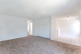 Located on Hayvenhurst Ave in Van Nuys, Los Angeles, this single-floor unit offers a straightforward, functional layout designed to maximize usability. The interior is finished with a consistent neutral palette of white walls and textured ceilings throughout, creating a clean, bright atmosphere.

The living area is generously sized, featuring wall-to-wall carpeting and a large window with vertical blinds that allows natural light to fill the room. A wall-mounted air conditioning unit provides climate control, and a entry door connects directly to the space. Adjacent to the living area, a hallway leads to the rest of the unit, where a large built-in cabinet with multiple doors offers substantial storage.

The kitchen is well-equipped with white cabinetry extending to the ceiling, providing ample storage. Light tile flooring, a double-basin sink, and a gas range with oven are key features. The layout allows for efficient use of counter space along the perimeter.

The bedrooms are carpeted and naturally lit through windows fitted with vertical blinds, each offering a closet. The bathroom includes tile flooring, an extended vanity with mirror, and a tub-shower combination enclosed by sliding glass doors, completing this practical and comfortable unit.