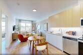 This well-appointed one-bedroom, one-bathroom residence in East Orange, NJ offers a thoughtfully designed layout that maximizes every square foot. Light oak hardwood flooring flows throughout, creating a warm and cohesive aesthetic across the entire unit.

The open-concept kitchen and living area serves as the heart of the home. The kitchen is outfitted with two-tone cabinetry — warm natural wood uppers paired with crisp white lowers — complemented by a clean white countertop, stainless steel appliances including a full-size range, dishwasher, microwave, and refrigerator, and under-cabinet lighting that adds a modern touch. A dining area sits adjacent, offering a natural transition into the bright living room, which features a large window that floods the space with natural light and provides outdoor views.

The generously sized bedroom includes a large double-door closet, wall-mounted sconce lighting, a broad window with outdoor views, and a calm, neutral color palette that promotes restful living. An additional closet provides further storage convenience.

The bathroom features large-format tile flooring, clean white walls, and a walk-in shower, maintaining the unit's modern and minimal aesthetic. In-unit laundry completes this efficient and comfortable home.