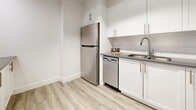 Located at 120 Torresdale Ave in Toronto's North York neighbourhood, this 2-bedroom, 1-bathroom unit offers a clean, modern interior with a cohesive and functional layout. Light-toned vinyl plank flooring flows consistently throughout every room, complementing the crisp white walls and bright trim that define the space's refreshed aesthetic.

The kitchen is a standout feature, equipped with white shaker-style cabinetry, dark countertops, a classic subway tile backsplash, and a full suite of stainless steel appliances including a refrigerator, stove with over-the-range microwave, and dishwasher. Natural light enters through a nearby opening that connects the kitchen seamlessly to the rest of the unit.

The spacious living room features large windows with views of the surrounding cityscape, baseboard heating, and an open connection to the hallway, creating an airy, unobstructed flow. Both bedrooms are comfortably sized, well-lit by windows, and include baseboard heating. The primary bedroom features a mirrored sliding closet door, adding both function and a sense of depth. The hallway connects all rooms efficiently with a ceiling-mounted light fixture overhead.

The bathroom is finished in all-white tile, featuring a full soaker tub with shower, a toilet, and a mirrored medicine cabinet — clean and practical in design.
