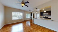 Located at 7902 E Country Dr in Laredo, TX, this single-floor residence offers a thoughtfully designed open-concept layout that seamlessly connects the living area and kitchen. The living room is finished with rich hardwood flooring that reflects natural light streaming in through multiple large windows fitted with blinds. A ceiling fan adds both function and character to the space. The kitchen features dark navy cabinetry, stainless steel appliances including a gas range, microwave, and refrigerator, granite countertops, and a peninsula with a built-in sink and pendant lighting overhead. Track lighting and a convenient built-in shelving unit add to the kitchen's practicality. An in-unit laundry area is directly accessible from the kitchen. The bedrooms are carpeted for comfort, each equipped with a ceiling fan and ample natural light. One bedroom includes a spacious walk-in closet and direct access to a bathroom with a soaking tub. The bathrooms are well-appointed with dark espresso cabinetry, granite countertops, and hardwood-style flooring. One bathroom features a glass-enclosed walk-in shower, while the other offers a full tub and shower combination. A glass door in one of the bedrooms opens to an outdoor area, further enhancing the bright, airy atmosphere throughout the residence.