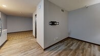 Located on Ogden Avenue in Ogden, Utah, this single-floor unit offers a practical and modern layout designed for comfortable living. The space is finished with durable wood-look luxury vinyl plank flooring throughout, complemented by dark baseboards and neutral gray walls that create a clean, contemporary aesthetic. A textured ceiling adds subtle character to each room.

The living area is well-proportioned and features a wall-mounted TV bracket, making it ready for immediate use. Recessed HVAC vents are integrated into the ceiling, ensuring efficient climate control. The entry door is solid and secure, opening into a welcoming foyer area.

The kitchenette is efficiently designed, featuring crisp white shaker-style cabinetry — both upper and lower — paired with a stainless steel full-size refrigerator, a built-in microwave, a cooktop, and a single-basin sink. Recessed lighting illuminates the workspace, and a patterned area rug adds a warm accent near the kitchen zone.

The bathroom is neatly appointed with a combination tub and shower unit, a modern single-sink vanity with a warm wood-toned cabinet, a white countertop, and a large wall mirror with a built-in light fixture above. The flooring continues the wood-look vinyl plank theme, tying the space together cohesively. Overall, the unit presents a move-in-ready, functional environment suited for a variety of occupants.