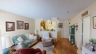 Located at 900 Westwood Dr in Winchester, Kentucky, this single-floor, one-bedroom, one-bathroom unit offers a practical and comfortable layout making efficient use of its space. The living room serves as the heart of the home, featuring warm hardwood flooring, a textured ceiling, and a large window that fills the room with natural light. A decorative electric fireplace unit anchors one wall, while an open pass-through connects the living area directly to the kitchen, promoting an open feel. The kitchen is well-appointed with warm wood cabinetry, dark granite-style countertops, a double basin sink, and white appliances including a range and refrigerator. There is also space for a small dining table, making it a functional and inviting cooking area. The bedroom is a comfortably sized retreat featuring hardwood floors, a textured ceiling, natural light from a curtained window, and notable closet storage. The unit includes five closets in total, providing excellent storage throughout. The bathroom features a wall-mounted sink, medicine cabinet with mirror, a shower with curtain enclosure, and tile flooring. With neutral wall tones throughout and a warm, lived-in character, this unit offers a cozy and efficient living environment.