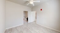 Located at 2100 N Leverett Ave in Fayetteville, Arkansas, this single-floor, one-bedroom, one-bathroom unit offers a well-organized layout designed for comfortable, practical living. Light-toned wood-look flooring runs throughout the entire space, creating a cohesive and clean aesthetic from room to room.

The combined kitchen and living area forms the heart of the unit. The kitchen is equipped with stainless steel appliances, including a refrigerator, range, dishwasher, and microwave, complemented by warm wood cabinetry and a light granite-style countertop with a double sink. A dedicated laundry area and a closet provide additional storage and convenience.

The bedroom is a bright, well-proportioned room featuring a ceiling fan with light fixture and a window fitted with blinds that allows natural light to filter in. The room connects directly to the bathroom and an additional closet, enhancing the sense of a private suite.

The bathroom is thoughtfully designed with ADA-accessible features, including sturdy grab bars positioned near the toilet and along the walls, a dark-toned vanity with a sink, and the same wood-look flooring found throughout the unit. Ceiling fans in both the main living area and bedroom ensure comfortable airflow year-round. Overall, this unit offers a clean, functional, and accessibility-conscious living environment.