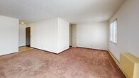 Located on Fleetwood Drive in Waukesha, Wisconsin, this two-bedroom, two-bathroom residence offers a well-organized single-floor layout designed for comfortable everyday living. The spacious living room features soft wall-to-wall carpeting, baseboard heating, and a sliding glass door that opens to a private balcony, allowing natural light to fill the space and providing outdoor views. A separate heating unit is also present along the living room wall, adding to the room's functionality.

The galley-style kitchen is equipped with warm wood cabinetry, ample upper and lower storage, a double sink with countertop workspace, and white appliances including a refrigerator and range, all set on easy-to-maintain tile flooring.

Both bedrooms are carpeted and bright, with the primary bedroom featuring a wide louvered bi-fold closet that provides generous storage. The second bedroom offers a window with natural light and convenient access to the rest of the unit via a solid wood door.

The two bathrooms are well-appointed — one includes a full tub and shower combo with classic white tiling accented by gold detail tiles, while the other features a marble-patterned countertop vanity with an integrated sink, a large mirror, and tile flooring. Together, these spaces create a functional and comfortable home.