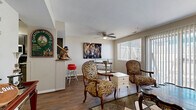 Located at 1432 McCain Ln in Manhattan, KS, this efficiently designed single-floor home offers a smart and functional layout across its one bedroom, one bathroom, and open-concept living space. The combined kitchen and living room serves as the heart of the home, where rich hardwood-style flooring flows throughout the living area, complemented by a ceiling fan and large windows with vertical blinds that invite ample natural light and views of the outdoors. A half-wall partition with a breakfast bar separates the living space from the kitchen, which features stainless steel appliances, grey cabinetry, marble-style countertops, a tile backsplash, and a cozy dining nook with tile flooring — ideal for casual meals. The living room offers generous space for seating arrangements and opens to a welcoming entryway accented by decorative mirrors and wall art. The bedroom is a calm retreat with plush carpeting, natural light from a window, and access to a dedicated closet. The full bathroom includes a shower-tub combination with tile surround. Throughout, the home maintains a clean, neutral palette that provides a versatile and inviting atmosphere.