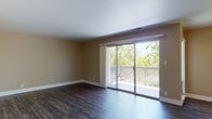 Located at 809 Hancock St in Hayward, California, this single-floor residence offers a well-organized layout with a variety of functional spaces finished with consistent, neutral design elements throughout.

The living area is a highlight of the home, featuring rich dark hardwood-style flooring and warm beige walls that create a welcoming atmosphere. Large sliding glass doors open directly onto a private deck, framed by mature trees that provide a pleasant natural backdrop and ample natural light.

The kitchen is efficiently designed with white shaker-style cabinetry, granite-look countertops, and white appliances including a dishwasher, refrigerator, and electric range. The dark hardwood flooring continues here, tying the space cohesively to the main living area.

The bedrooms are carpeted in neutral tones, offering a softer, quieter environment. One bedroom features a ceiling fan and a window with outdoor views, while additional bedrooms provide similarly comfortable spaces with natural light.

The bathrooms are appointed with granite-look countertops, white vanity cabinetry, brushed nickel fixtures, and hardwood-style flooring. One bathroom includes a separate water closet for added privacy. Clean white trim and consistent finishes unify the overall aesthetic of the home.
