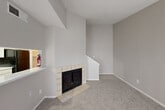Located at 10401 Old Bammel N Houston Road in Houston, TX, this two-story, 3-bedroom, 3-bathroom home offers a practical and comfortable layout across two floors. The main level provides the majority of the living space, featuring two distinct living areas, a combined dining room and kitchen, a laundry area, and a full bathroom. The open living room is highlighted by a tile-surround fireplace, vaulted ceilings that lend a sense of height and openness, and plush carpeting underfoot. Natural light filters in through large windows and a sliding glass door. A staircase with a white banister connects both levels with ease. The galley-style kitchen is equipped with white cabinetry, a marble-look countertop, wood-look vinyl flooring, a skylight overhead, and black appliances including a refrigerator and range. The upper floor houses all three bedrooms, each carpeted and featuring windows that bring in natural light, along with four closets for ample storage. The three bathrooms are clean and functional, featuring tub-shower combinations and wood-look vinyl flooring. Neutral tones throughout create a cohesive, move-in-ready aesthetic.