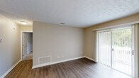 Located at 160 Bella Dr in Fayetteville, GA, this single-story, one-bedroom, one-bathroom home offers a well-organized layout across a comfortable footprint. The living room features wood-style plank flooring, neutral warm-toned walls, a textured ceiling, and a sliding glass door fitted with vertical blinds that invites natural light and provides outdoor access. A standout wood-burning fireplace with a classic surround anchors one end of the living area, adding both character and warmth. The galley-style kitchen is well-appointed with white cabinetry, a tile mosaic backsplash, light countertops, a stainless steel sink, and black appliances including a range and refrigerator. Adjacent to the kitchen, the dining area is defined by a pendant light fixture and continues the hardwood-style flooring throughout. The spacious bedroom is carpeted for comfort, features a ceiling fan with light, a large closet, and a window with natural views. The bathroom includes a white vanity with a single-basin sink, a tub-shower combination, a large mirror, and a window with garden views. A dedicated closet provides additional storage, completing this efficiently designed and move-in ready home.