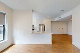Located at 100 Cabot Street in Boston, MA, this modern residence offers four bedrooms and two full bathrooms across a single thoughtfully designed floor. The open-concept living and kitchen area forms the heart of the home, featuring warm hardwood flooring that extends throughout the space. The kitchen is equipped with stainless steel appliances — including a full-size refrigerator, oven, microwave, and dishwasher — complemented by crisp white cabinetry, light-toned countertops, and a peninsula with a sink that opens toward the living area. A window above the kitchen counter allows natural light to fill the space. The living area is bright and clean-lined, with recessed lighting and a welcoming entry foyer equipped with a smart lock and intercom panel. Each of the four bedrooms features hardwood flooring and windows that bring in natural light and views of the surrounding neighborhood. The primary bedroom is a comfortable and well-proportioned retreat. Both bathrooms are finished in a clean, contemporary style with tile flooring, white vanities, large mirrors, and a full tub-shower combination. The overall aesthetic is modern and neutral, offering a versatile, move-in-ready living environment in the heart of Boston.