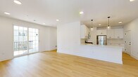 This well-appointed 2-bedroom, 2-bathroom residence at 50 Kirby Ave in Somerville, NJ offers a thoughtfully designed open-concept layout finished with light hardwood flooring throughout. The combined living and dining area is bright and airy, illuminated by recessed lighting and a sliding glass door that opens to a private balcony, filling the space with natural light and outdoor views.

The kitchen is seamlessly integrated into the living area via a peninsula counter, and features white shaker cabinetry, a classic subway tile backsplash, stainless steel appliances including a refrigerator and microwave, and sleek pendant lighting — creating a functional yet stylish cooking space.

The generously sized primary bedroom offers a ceiling fan, large windows with natural light, and direct access to a luxurious en-suite bathroom. The primary bath is a standout feature, boasting a floating dual-sink vanity with dark navy cabinetry, white quartz countertops, dual framed mirrors, and a glass-enclosed walk-in shower. The second bedroom is well-proportioned and sun-filled. The second bathroom includes a combined tub and shower with a single-sink vanity. Clean white walls, modern black hardware, and consistent hardwood flooring unify the space with a fresh, contemporary aesthetic.