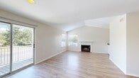 Located at 100 Christina Mill Dr in Newark, Delaware, this thoughtfully designed 2-bedroom, 2-bathroom home offers a comfortable and functional single-floor layout. The bright living room features vaulted ceilings, a classic brick fireplace, and light hardwood flooring, with a sliding glass door that opens to an outdoor balcony and allows generous natural light to fill the space. The open-concept kitchen is a standout, outfitted with white cabinetry, granite countertops, a peninsula with a built-in sink, and a full suite of stainless steel appliances including a refrigerator, range, microwave, and dishwasher. Hardwood flooring flows seamlessly through the main living and dining areas. The primary bedroom offers vaulted ceilings, an elegant arched window, plush carpeting, and ample closet space. The second bedroom is equally inviting, featuring a ceiling fan, a large window with outdoor views, and soft carpeting. Both bathrooms are finished with granite-topped vanities and tiled shower-tub combinations with brushed nickel fixtures. The home also includes a dedicated laundry area, four closets for generous storage, and two hallways connecting the well-organized layout throughout.