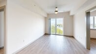 Located at Coco Plum Drive in Marathon, Florida, this two-bedroom, two-bathroom unit offers a clean, contemporary design throughout its single-floor layout. Light wood-style flooring runs consistently across all rooms, lending a cohesive and airy feel to the space.

The open living area is a standout feature, anchored by a sliding glass door that opens to a private balcony overlooking lush treetops and a scenic waterway — a classic Florida Keys backdrop. A ceiling fan overhead and abundant natural light enhance the comfort of this central gathering space.

The kitchen is well-appointed with dark wood-grain cabinetry, light countertops, a stainless double-basin sink, and black appliances including a refrigerator, range with over-the-range microwave, and dishwasher. Recessed lighting adds a polished finish.

Both bedrooms feature light-toned walls, wood-style flooring, and ceiling fans. The primary bedroom includes a window with waterway views. Each bathroom is fitted with a tub-shower combination, light wood flooring, and brushed nickel fixtures and grab bars. One bathroom includes a dark wood vanity with ample drawer storage.
