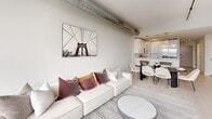 Located at 315 15th Street in Jersey City, NJ, this modern 2-bedroom, 2-bathroom residence offers a well-designed single-floor layout with clean, contemporary finishes throughout. The open-concept living area is a standout, featuring floor-to-ceiling windows that flood the space with natural light and frame sweeping views of the New York City skyline and surrounding cityscape. Exposed industrial-style ductwork adds an urban loft character to the living and dining area, which flows seamlessly into a sleek kitchen outfitted with white cabinetry and pendant lighting. Light wood-tone flooring runs consistently throughout, enhancing the bright, airy atmosphere. The spacious primary bedroom is a serene retreat, boasting expansive floor-to-ceiling windows with dramatic skyline views, light-toned walls, and access to a generous walk-in closet complete with built-in shelving and hanging rods. The second bedroom is well-proportioned and similarly finished with soft neutral tones. Both bathrooms are appointed with large-format marble-look tile flooring, dark wood vanities, and well-lit mirrors, delivering a polished, upscale feel. A hallway connects the rooms efficiently, contributing to a smart and functional floor plan throughout this stylish Jersey City residence.