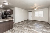 This two-floor residence offers a thoughtfully laid-out living environment with a blend of practical features and comfortable design. The main level showcases an open-concept kitchen and living area, where rich dark cabinetry with granite-look countertops pairs with black appliances, including a refrigerator, range, and dishwasher. Wood-look plank flooring flows throughout the kitchen and living spaces, complemented by textured ceilings and ceiling fans that add character to each room. A chandelier over the kitchen peninsula adds a touch of elegance, while a window in the living area allows natural light to brighten the space.

The bedrooms are carpeted for comfort and feature ceiling fans, generous closet space with built-in shelving, and easy access to the bathrooms. The bathrooms are well-appointed with dark vanity cabinetry, framed mirrors, and tub-shower combinations, all finished with the same wood-look flooring found elsewhere in the home.

A dedicated laundry area houses a full-size washer and dryer alongside additional shelving, providing excellent utility and storage. The lower level features a secondary kitchen or kitchenette space with matching dark cabinetry and wood-look flooring, making it a versatile area suited for a variety of uses. Throughout both floors, the design maintains a cohesive, neutral palette with dark trim accents.