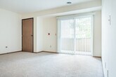 Located at 2333 Columbus Ln in Madison, WI, this single-floor, 3-bedroom, 2-bathroom home offers a practical and comfortable layout. The living area features plush carpeting and large sliding glass doors fitted with vertical blinds that open to a private balcony, flooding the space with natural light and providing views of surrounding greenery. The kitchen is well-equipped with warm oak cabinetry, white appliances including a refrigerator, range, and dishwasher, and a skylight that adds additional brightness. The tile flooring in the kitchen carries a neutral stone-like pattern that complements the cabinetry. The generously sized primary bedroom includes a mirrored sliding closet and a window with vertical blinds. The two additional bedrooms are carpeted and bright, each with windows overlooking the outdoors. Two full bathrooms serve the home — one featuring a vanity with a medicine cabinet mirror and tile flooring, and the other with a full tub/shower combination and warm wood cabinetry. Two dedicated closets, including a spacious walk-in with wire shelving, provide ample storage. Warm wood trim and baseboards carry throughout, giving the home a cohesive, classic aesthetic.