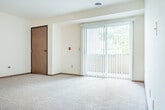 Located at 2333 Columbus Ln in Madison, WI, this single-floor, 3-bedroom, 2-bathroom home offers a practical and comfortable layout. The living area features plush carpeting and large sliding glass doors fitted with vertical blinds that open to a private balcony, flooding the space with natural light and providing views of surrounding greenery. The kitchen is well-equipped with warm oak cabinetry, white appliances including a refrigerator, range, and dishwasher, and a skylight that adds additional brightness. The tile flooring in the kitchen carries a neutral stone-like pattern that complements the cabinetry. The generously sized primary bedroom includes a mirrored sliding closet and a window with vertical blinds. The two additional bedrooms are carpeted and bright, each with windows overlooking the outdoors. Two full bathrooms serve the home — one featuring a vanity with a medicine cabinet mirror and tile flooring, and the other with a full tub/shower combination and warm wood cabinetry. Two dedicated closets, including a spacious walk-in with wire shelving, provide ample storage. Warm wood trim and baseboards carry throughout, giving the home a cohesive, classic aesthetic.