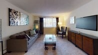 This single-floor residence at 158 Concord Rd in Billerica, Massachusetts offers a well-organized and functional layout designed for comfortable everyday living. The kitchen is efficiently arranged in an L-shaped configuration, outfitted with warm honey-toned cabinetry, dark granite countertops, and a full suite of stainless steel appliances including a gas range, over-the-range microwave, refrigerator, and dishwasher. Light tile flooring completes the practical yet inviting cooking space. The living room features plush wall-to-wall carpeting and a large window dressed with floor-length curtains, allowing natural light to filter in while maintaining privacy. A wall-mounted HVAC unit provides climate control throughout the space. The residence includes two well-proportioned bedrooms, each finished with soft carpeting, natural light from large windows with outdoor views, and ample closet storage. Both rooms offer a calm, restful ambiance suited for relaxation. The full bathroom is finished with beige tile on both the floors and tub surround, accompanied by a soaking tub and shower combination, a toilet, and overhead cabinetry for additional storage. Throughout the residence, neutral tones and consistent finishes create a cohesive and welcoming atmosphere.