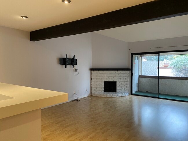 Living area with TV mount and hidden cables. - 15155 Sherman Way