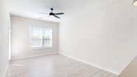Located at 3145 Prado Ln in Charlotte, NC, this thoughtfully designed single-floor residence offers a clean, modern aesthetic throughout its well-organized layout. Light wood-look flooring flows continuously across the space, complementing the neutral, warm-toned walls and creating a bright, cohesive atmosphere.

The open-concept kitchen and living area serves as the heart of the home. The kitchen is outfitted with crisp white shaker cabinets, stone countertops, a herringbone tile backsplash, stainless steel appliances — including a French door refrigerator, range, and microwave — and a large island with an undermount sink and pendant lighting overhead. The adjoining living area is generously proportioned, featuring a ceiling fan with lighting and windows fitted with blinds that allow for natural light control. A door leads directly to a private patio, extending the living space outdoors.

The bedroom is a comfortable, well-lit retreat with a ceiling fan, a large window framing outdoor greenery, and direct access to a dedicated walk-in closet. The full bathroom is finished with a stone-top vanity, subway tile walk-in shower enclosed by a sliding frameless glass door, and light wood-look flooring. Additional conveniences include an in-unit laundry area and a hallway connecting all rooms efficiently.