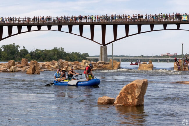 People in The Big Dam Party event navigate their raft through the river.