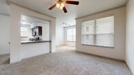 Located at 15330 Liberty River Dr in Houston, TX, this single-story residence offers a thoughtfully designed open-concept layout that promotes a comfortable and functional living experience. The living area is spacious and carpeted, filled with natural light streaming through large windows dressed with horizontal blinds. A ceiling fan overhead adds to the airy feel of the space. The kitchen is seamlessly connected to the living area via a pass-through counter, and features rich dark wood cabinetry, granite-style countertops, hardwood-style flooring, and black stainless steel appliances including a side-by-side refrigerator, electric range, built-in microwave, and dishwasher. Track lighting illuminates the kitchen and adjoining dining area. The bedrooms are carpeted and bright, each benefiting from natural light through well-placed windows. The bathroom is clean and functional, showcasing a vanity with dark wood cabinetry and granite-style countertops, a tiled tub-shower combo, and tile flooring. A generously sized walk-in closet with wire shelving provides ample storage. A hallway closet with louvered doors adds additional convenience. The overall ambiance is light, neutral, and move-in ready.