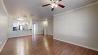 This well-designed two-story home offers a thoughtful layout spread across two levels. The ground floor serves as the entry point, featuring tile flooring in the hallway, an attached garage with an automatic door opener, a laundry area, and interior access via a staircase with warm wood-toned treads and a white railing leading to the main living spaces above.

The upper level is where the home truly opens up. The combined living and dining area is bright and inviting, showcasing rich hardwood flooring, crown molding, and a ceiling fan, creating a comfortable, airy atmosphere. The adjacent kitchen is a standout, equipped with dark granite countertops, white cabinetry, a subway tile backsplash, stainless steel appliances, and a built-in pantry with open shelving.

The three bedrooms are carpeted and feature ceiling fans and windows that bring in natural light. The primary bedroom includes a walk-in closet with wire shelving. The bathrooms are well-appointed, with one featuring a double-sink vanity with dark granite countertops, white cabinetry, a large mirror, and a soaking tub with tiled surround. Additional spaces include a dedicated office, multiple closets, and hallways that connect the layout efficiently.