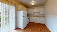 Located at 5200 Lewis Rd in Sandston, Virginia, this two-floor home offers a practical and straightforward layout designed for comfortable everyday living. The main level features a welcoming living area with warm carpet flooring and a staircase with a metal railing leading to the upper floor. Natural light filters in through windows fitted with blinds, creating a bright and airy atmosphere throughout. An opening connects the living area to an adjacent dining space, which is illuminated by a chandelier and offers access to the exterior through a sliding glass door. The kitchen is well-appointed with white cabinetry extending to the ceiling for ample storage, wood-look flooring, and full-size appliances including a refrigerator and range. The bathroom features a tub-shower combination with built-in shelving, white subway tile accents with navy border detailing, a vanity with a mirrored medicine cabinet, and a sink. The bedrooms are carpeted and filled with natural light from windows, with at least one room offering a double-door closet for generous storage. Overall, the home presents a clean, functional design with consistent neutral tones throughout both floors.