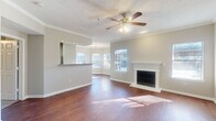 Located at 8383 El Mundo St in Houston, TX, this single-story, 3-bedroom, 2-bathroom home offers a well-designed layout that balances comfort and functionality. The living room serves as the heart of the home, showcasing rich hardwood-style flooring, crown molding, a textured ceiling, a ceiling fan with light fixture, and a classic white-mantled fireplace flanked by windows that invite ample natural light. A hallway connects the living area to the bedrooms, maintaining a smooth flow throughout the residence. The kitchen is equipped with rich cherry-toned cabinetry, granite countertops, stainless steel appliances including a range and microwave, a tile backsplash, and light tile flooring. It opens to the dining area through an arched entryway, adding architectural charm. The bedrooms feature plush carpeting, ceiling fans, and sliding glass doors or windows with outdoor views. The primary bedroom offers a generous footprint with access to natural light. Both bathrooms are finished with warm stone-toned tile surrounds, soaking tubs, and rich wood vanity cabinetry with granite countertops. Two closets and a hallway complete this efficient and inviting floor plan.