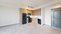This compact yet thoughtfully designed 520 square foot apartment in Miami offers a harmonious blend of functionality and style. The space comprises one bedroom, one bathroom, and an open-concept living area. The kitchen is a standout feature, boasting sleek wood cabinetry, contrasting black appliances, and a practical L-shaped layout. Large windows in the bedroom and living area flood the space with natural light and provide stunning city views, enhancing the sense of spaciousness. The bathroom is efficiently designed with a combined shower and tub, white tiled walls, and a modern vanity. Throughout the apartment, neutral-toned tile flooring creates a cohesive look and easy maintenance. The bedroom, measuring 130 square feet, offers ample space for a comfortable retreat. Despite its modest size, the apartment includes a hallway and closet space, ensuring storage needs are met. Located at 610 NW 10th St in Miami, this single-floor residence represents urban living at its most efficient and stylish.