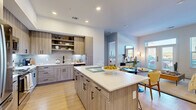 This thoughtfully designed 2-bedroom, 2-bathroom residence offers a seamless single-floor layout with modern finishes and a bright, open feel throughout. The heart of the home is a contemporary open-concept kitchen and living area, where wood-toned cabinetry with matte black hardware, a classic subway tile backsplash, stainless steel appliances, and a large central island with crisp white countertops create an inviting and functional space. Open shelving adds both style and practicality, while light hardwood flooring flows continuously through the living and dining areas, enhancing the sense of space. A generously sized living and dining area receives ample natural light through large windows and glass doors, which lead to an outdoor balcony area. The primary bedroom is a serene retreat, featuring multiple windows with outdoor views and warm, neutral tones. It is complemented by a well-appointed en-suite bathroom and a spacious walk-in closet with built-in shelving and hanging rails. The second bedroom is equally bright and comfortable, with its own closet and convenient access to the second full bathroom. Two dedicated closets provide ample storage throughout. The overall ambiance is clean, contemporary, and welcoming, with consistent light-toned finishes tying every room together cohesively.
