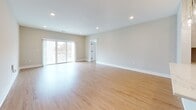 This single-floor unit at 269 Fuller Rd in Albany, NY offers a thoughtfully designed open-concept layout with clean, modern finishes throughout. The expansive main living area features light hardwood flooring, recessed lighting, and neutral walls that create a bright and welcoming atmosphere. Large sliding glass doors lead to an outdoor balcony, allowing natural light to fill the space while providing outdoor access and views.

The kitchen is well-appointed with shaker-style cabinetry in a soft gray-beige tone, stainless steel appliances including a French door refrigerator, a gas range with a wall-mounted hood, and a white quartz peninsula with an undermount sink. Stylish globe pendant lights add a contemporary touch overhead.

Bedroom areas are carpeted for comfort, with neutral walls and windows fitted with horizontal blinds. One bedroom includes a sliding-door closet with built-in rods and shelving, while another features a generous walk-in closet outfitted with dark, adjustable shelving units and dual hanging rods for organized storage.

The bathroom is finished with large-format, light stone-look tile on both the floor and tub surround, complemented by a dark espresso vanity with a white countertop and a framed mirror. Overall, the unit presents a cohesive, contemporary aesthetic throughout.