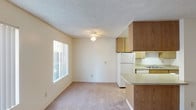 Located at 12840 Mapleview in Lakeside, this single-story unit offers a practical, well-organized layout designed for comfortable everyday living. The spacious living room is finished with neutral carpet and features multiple windows dressed with vertical blinds, allowing natural light to fill the space. A wall-mounted air conditioning unit provides climate control, and a entry door leads directly from this room.

The kitchen is efficiently arranged with warm wood-toned cabinetry extending to the ceiling for ample storage, laminate tile flooring, a full-size refrigerator, dishwasher, range, and a double-basin sink. A breakfast bar countertop connects the kitchen to the adjacent dining or living area, creating an open, functional flow.

The unit includes multiple carpeted bedrooms, each featuring textured ceilings, neutral walls, and natural light from windows. One bedroom includes a built-in closet with sliding doors, while others offer access to additional storage. Two bathrooms serve the unit, each equipped with a full tub and shower combination and tile flooring, providing practical functionality throughout.