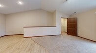 This two-story home in Hutchinson, MN offers a thoughtfully designed layout across two levels, with the main living areas occupying the upper floor. The kitchen is a functional highlight, featuring rich dark-stained cabinetry, stone countertops, stainless steel appliances, a breakfast bar peninsula, and light hardwood-style flooring accented by recessed lighting overhead. The open flow from the kitchen connects naturally to the surrounding living areas.

Both bedrooms are carpeted for comfort. The primary bedroom impresses with dramatic vaulted ceilings, warm neutral tones, and access to a dedicated walk-in closet with built-in shelving. The second bedroom features a ceiling fan, a large window with natural light, and a three-panel solid wood door — a detail consistent throughout the home. Three full bathrooms serve the residence, including one with a walk-in shower, and another with a vanity featuring dark cabinetry and a white countertop. A dedicated laundry room houses a side-by-side washer and dryer with overhead wire shelving for added storage. The lower level provides direct access to an attached garage. Carpeted stairs with a wooden handrail connect the floors. Three closets throughout the home offer ample storage for everyday needs.
