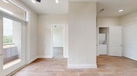 Located at 900 New Day Avenue in Montgomery, TX, this thoughtfully designed single-story home offers two bedrooms and two bathrooms within a smartly utilized floor plan. The interior is finished in a clean, neutral palette with warm wood-look tile flooring that runs seamlessly throughout the living areas, creating a cohesive and modern aesthetic.

The kitchen serves as a functional centerpiece, showcasing crisp white shaker cabinets with matte black hardware, a classic hexagon tile backsplash, light countertops, and a full suite of stainless steel appliances including a French door refrigerator, built-in double wall oven, microwave, and dishwasher. A dedicated laundry closet with a stacked washer and dryer is conveniently accessible from the kitchen area.

The bedrooms are bright and welcoming, each featuring large black-framed windows that frame views of the surrounding landscape and allow generous natural light to fill the rooms. Each bedroom is paired with its own closet for ample storage.

The bathrooms are finished to a high standard, with one featuring a walk-in glass-enclosed shower adorned with marble-style tile walls, wood-look flooring, a white vanity, and accessibility grab bars — combining style with practicality. The overall ambiance of the home is clean, contemporary, and move-in ready.