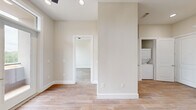 Located at 900 New Day Avenue in Montgomery, TX, this thoughtfully designed single-story home offers two bedrooms and two bathrooms within a smartly utilized floor plan. The interior is finished in a clean, neutral palette with warm wood-look tile flooring that runs seamlessly throughout the living areas, creating a cohesive and modern aesthetic.

The kitchen serves as a functional centerpiece, showcasing crisp white shaker cabinets with matte black hardware, a classic hexagon tile backsplash, light countertops, and a full suite of stainless steel appliances including a French door refrigerator, built-in double wall oven, microwave, and dishwasher. A dedicated laundry closet with a stacked washer and dryer is conveniently accessible from the kitchen area.

The bedrooms are bright and welcoming, each featuring large black-framed windows that frame views of the surrounding landscape and allow generous natural light to fill the rooms. Each bedroom is paired with its own closet for ample storage.

The bathrooms are finished to a high standard, with one featuring a walk-in glass-enclosed shower adorned with marble-style tile walls, wood-look flooring, a white vanity, and accessibility grab bars — combining style with practicality. The overall ambiance of the home is clean, contemporary, and move-in ready.