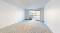 Located at 55 Rue Hasting in Dollard-Des-Ormeaux, this 2-bedroom, 1-bathroom unit offers a practical and well-organized single-floor layout. The entry leads through a hallway into a bright, open-concept living and dining area, where large sliding glass doors flood the carpeted space with natural light and provide direct access to a private balcony with exterior views. The kitchen is positioned at the heart of the unit, featuring a wrap-around peninsula with a bold red countertop, warm wood cabinetry, ample upper and lower storage, tile flooring, and an integrated sink — all visible and accessible from the living area. The primary bedroom is a generous, sun-lit room with carpet flooring, a large window, and its own closet. The second bedroom is equally bright with carpet flooring and a closet. Both rooms benefit from natural light. The full bathroom includes a single-sink vanity with a warm countertop, a tiled tub-shower surround, and tile flooring. A utility room and four closets throughout the unit offer notable storage capacity. The textured ceilings and baseboard heating are consistent throughout, giving the space a cohesive character.