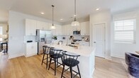 This contemporary 1450 sq ft home in Cornelius, NC offers a perfect blend of style and functionality. The single-story layout features 2 bedrooms, including a spacious 180 sq ft primary suite, and 3 well-appointed bathrooms. The heart of the home is a stunning open-concept kitchen and living area, showcasing crisp white cabinetry, stainless steel appliances, and a large island with seating for casual dining.

Hardwood floors flow throughout, complementing the neutral color palette and enhancing the home's bright, airy feel. Large windows in every room, including the dedicated office space, flood the interior with natural light. The dining room, adorned with modern fixtures, provides an elegant setting for formal meals.

Additional amenities include a laundry room with ample storage, a garage for convenient parking, and multiple closets for organization. The bathrooms feature contemporary fixtures and finishes, with at least one offering a combination tub-shower.

Outdoor views are accessible from various rooms, suggesting a connection to nature. The home's thoughtful design and high-end finishes create a harmonious living environment that balances comfort with sophistication.