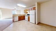 Located at 14320 Dysprosium St NW in Ramsey, Minnesota, this single-floor residence offers a practical and comfortable layout with well-defined living spaces throughout. The living area is generously sized, featuring soft wall-to-wall carpeting, baseboard heating, and a sliding glass door that opens to a private balcony with views of the surrounding autumn foliage, allowing abundant natural light to fill the room. The kitchen is equipped with warm oak cabinetry, a full suite of white appliances including a refrigerator, electric range, and dishwasher, complemented by light countertops and tile flooring. A ceiling fan provides additional comfort in the adjoining dining area. The bedrooms are carpeted and well-lit, each featuring baseboard heating and ample closet space with built-in shelving. Natural light streams through the windows, creating a bright and airy atmosphere. The bathroom includes an extended vanity with generous cabinet storage, a large mirror, and tile flooring that connects seamlessly to the rest of the unit. A dedicated laundry area with an in-unit washer adds everyday convenience. The overall design is clean and functional, with a neutral warm palette carried consistently throughout the space.