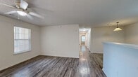 Located at 500 Kraft St in Clarksville, Tennessee, this single-floor, 3-bedroom, 2-bathroom home offers a practical and comfortable layout. The living room greets you with wood-style hard flooring, a ceiling fan with light fixture, and large windows alongside a glass-paneled door that invite natural light and outdoor views. The kitchen is designed in a galley style, featuring light wood cabinetry, white appliances including a refrigerator and range, a stainless steel sink, and a breakfast bar peninsula that opens toward the living area — ideal for casual dining or entertaining. Both bathrooms are finished with wood-style flooring and light wood vanities; one includes a shower-tub combination, while the other features an open vanity layout. The three bedrooms are carpeted for comfort, each with neutral white walls and ceiling fans. The primary bedroom is generously sized and connects to the hallway, while secondary bedrooms include features such as double bi-fold closet doors and windows with views of surrounding greenery. A dedicated closet provides additional storage. Textured ceilings and clean white trim are consistent throughout, giving the home a cohesive, well-maintained appearance.