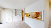 Located at 1714 Lafayette Blvd in Fredericksburg, VA, this two-bedroom, one-bathroom residence offers a practical and comfortable single-floor layout. The combined dining, kitchen, and living area forms the heart of the home, where a pass-through counter connects the galley-style kitchen to the open living space. The kitchen features warm wood cabinetry, light countertops, a gas range, dishwasher, and full-size refrigerator, all set atop durable wood-look flooring. The living room is carpeted and bright, highlighted by a set of built-in wall shelves and large sliding glass doors that open directly onto a private balcony with pleasant outdoor views. Both bedrooms are carpeted and well-sized, each offering good natural light through dedicated windows. The primary bedroom provides a comfortable retreat with ample room. Five closets throughout the unit offer exceptional storage. The full bathroom includes a tiled tub-shower combination. A hallway connects the rooms efficiently, contributing to the home's well-organized flow. Neutral tones throughout create a clean, versatile backdrop suited to a variety of décor styles.
